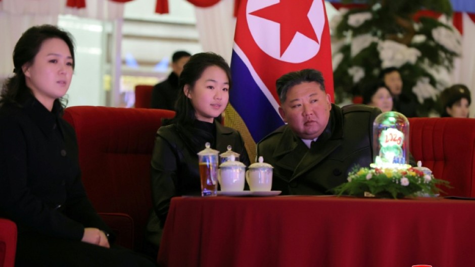This picture taken on December 31, 2025 and released by North Korea's official Korean Central News Agency (KCNA) via KNS on January 1, 2026 shows North Korean leader Kim Jong Un, his daughter Kim Ju Ae (C) and wife Ri Sol Ju (L) watching a New Year's celebration performance at the May Day Stadium in Pyongyang