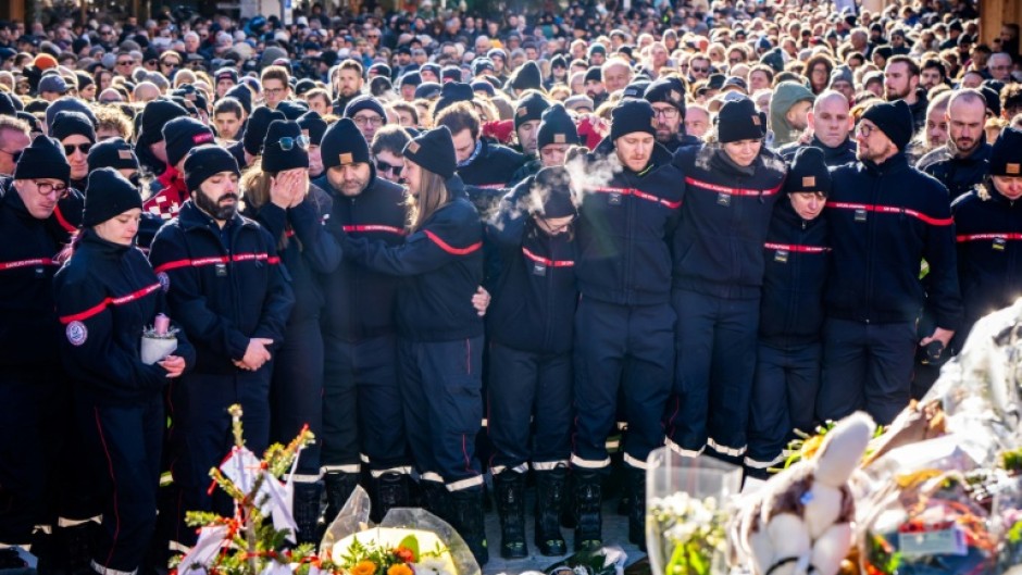 Firefighters from the Municipality of Crans-Montana gathered around a makeshift memorial to pay their respects