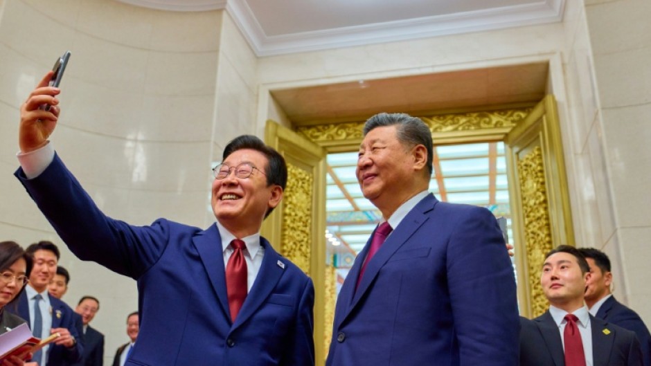 South Korea's President Lee Jae Myung (L) takes a selfie with China's President Xi Jinping (R) after a dinner at the Great Hall of the People in Beijing on January 5, 2026