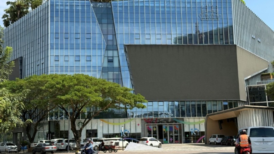 Motorists ride past the Prince Group Headquarters in Phnom Penh