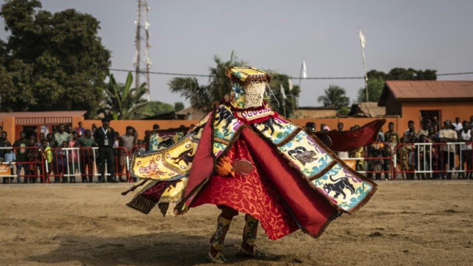 A costumed Egungun figure, revering ancestors, dances during festivities last January in Ouidah