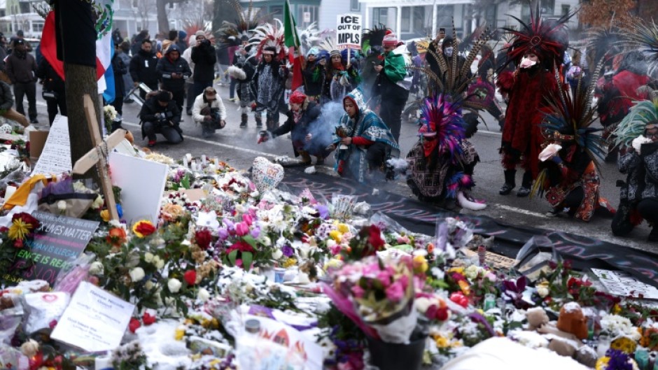 Demonstrators march past a makeshift memorial for 37-year-old Renee Nicole Good, who was shot and killed on January 7 by a US Immigration and Customs Enforcement (ICE) agent in Minneapolis, Minnesota