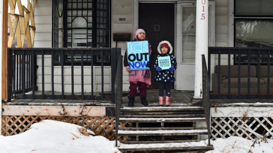 Children hold signs along the route of the protest march in Minneapolis