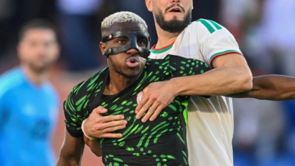 Osimhen holds off Ramy Bensebaini during Nigeria's quarter-final win over Algeria in Marrakesh