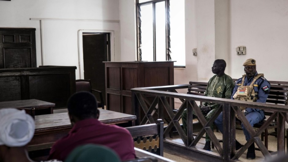 Manjang sits in the dock at the High Court in Banjul