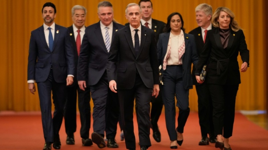 Canada's Prime Minister Mark Carney (C) arrives for meeting with Chinese President Xi Jinping at the Great Hall of the People in Beijing