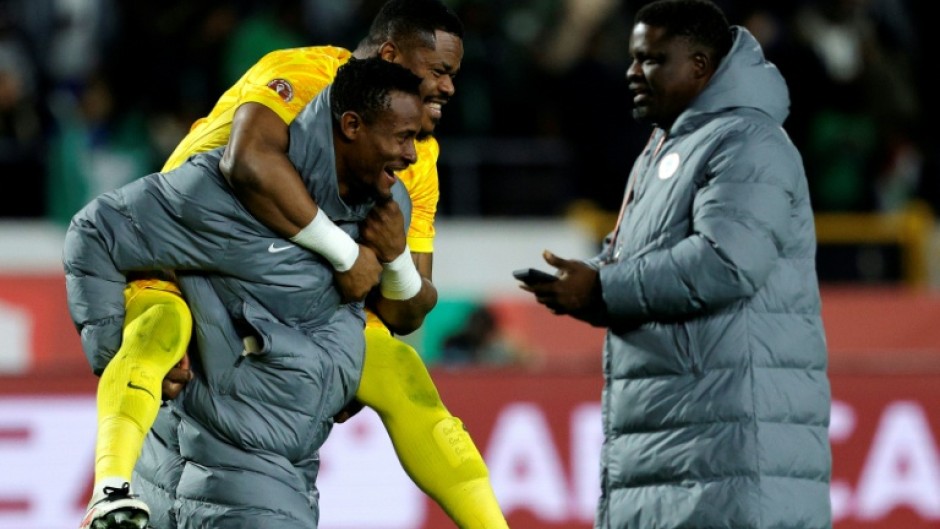 Nigeria reserve goalkeeper Amas Obasogien carries Stanley Nwabali, who saved two penalties in a shoot-out victory over Egypt in the Africa Cup of Nations third place play-off.