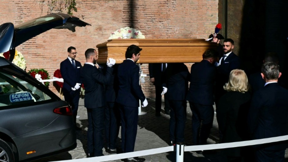 Pallbearers carry the coffin of the late Italian fashion designer Valentino Gavarani to enter the Basilic of Santa Maria degli Angeli e dei Martiri for a funeral ceremony, in Rome on January 23, 2026.