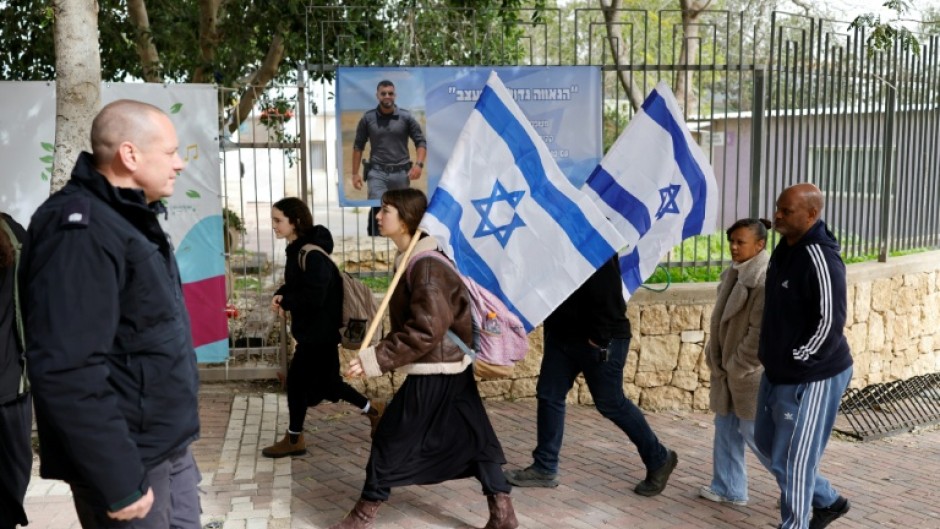Mourners carrying Israeli flags gathered for the funeral ceremony in Meitar