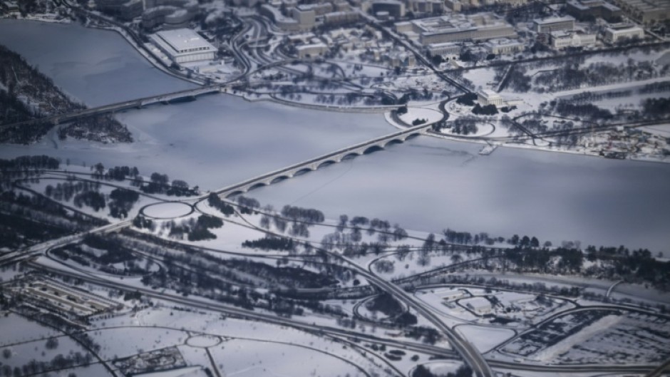This aerial view shows a snow-covered Washington, DC, including the Lincoln Monument, the Kennedy Center, the Potomac River and the National Mall from Air Force One