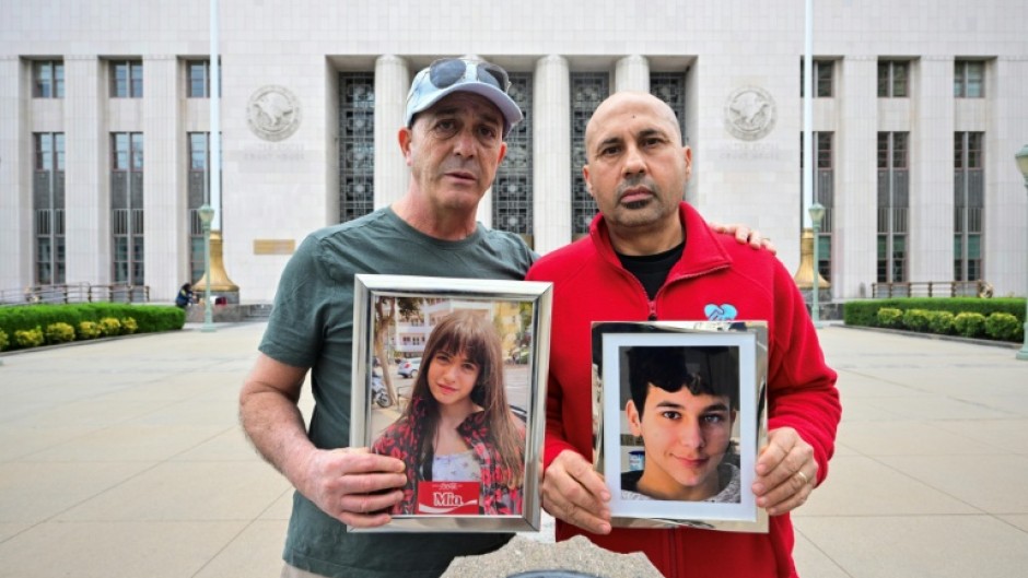 Parents Mariano Janin and George Nicolaou hold photos of their children outside the Los Angeles County Superior Court in Los Angeles