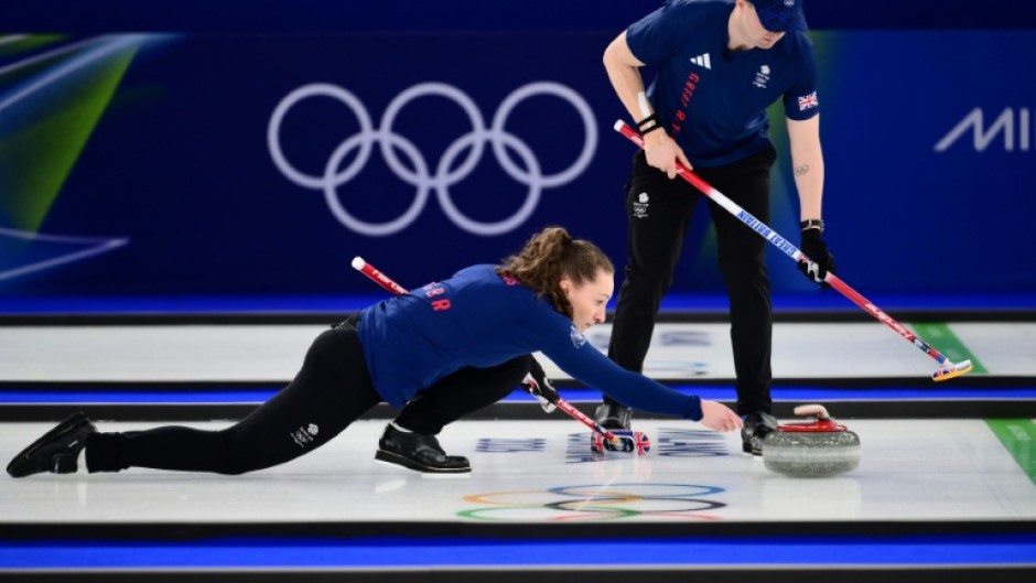 Britain's Jen Dodds aims her stone as her partner Bruce Mouat looks on during their victory in the curling mixed doubles, the opening event of the Winter Olympics