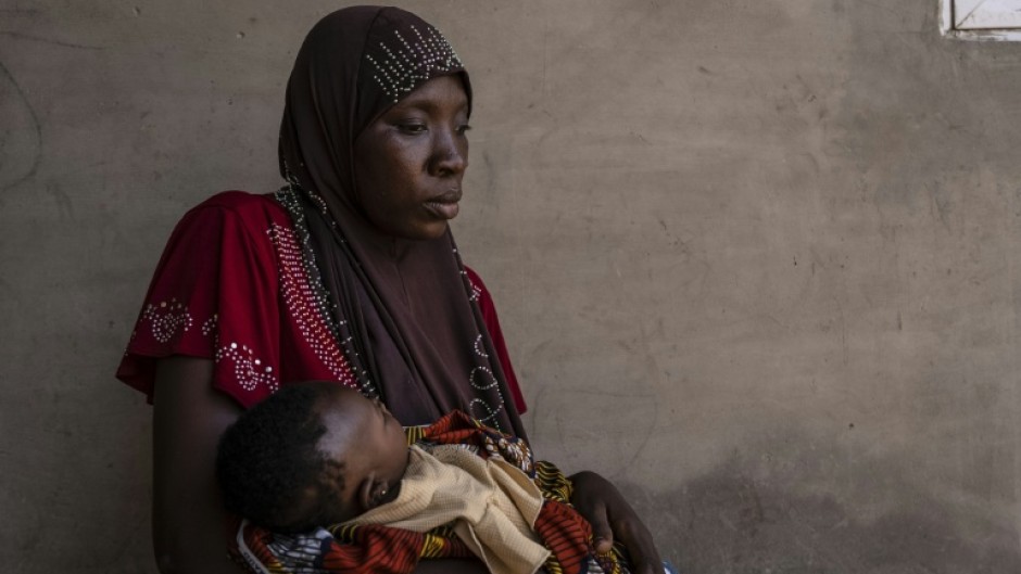 Khausara Saleem, 28, holds her three-month-old baby after fleeing the massacre in the Nigerian village of Woro