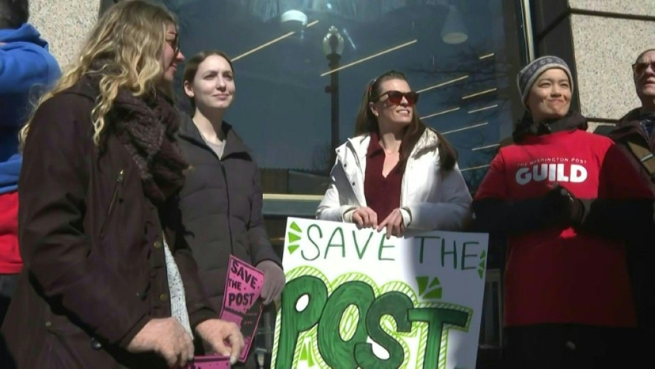 People rally in front of the Washington Post following massive layoffs