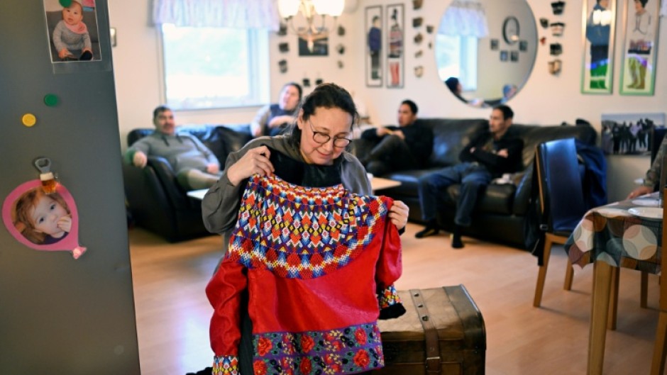 Dorthe Olsen holds up traditional clothing at her home in Sarfannguit