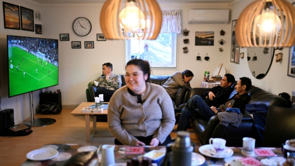 A giant flat screen in Olsen's house shows a football match from England's Premier League