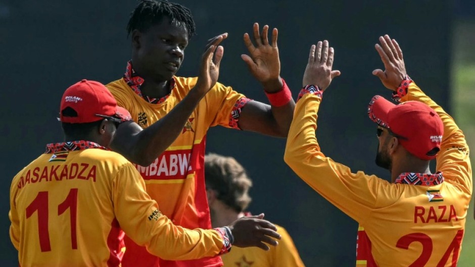 Zimbabwe's Blessing Muzarabani (2L) celebrates with teammates after taking the wicket of Oman's captain Jatinder Singh