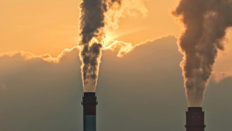 Smoke rises from chimneys at a power plant during sunset in Taicang, in eastern China's Jiangsu province