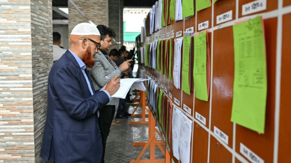 Members of the media look at documents of preliminary election results at the Election Commission office in Dhaka on February 13, 2026