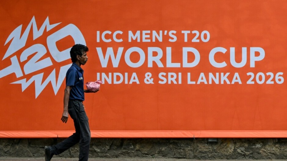A man walks past a billboard advertising the 2026 ICC Men's T20 Cricket World Cup, at the Sinhalese Sports Club (SSC) cricket stadium in Colombo