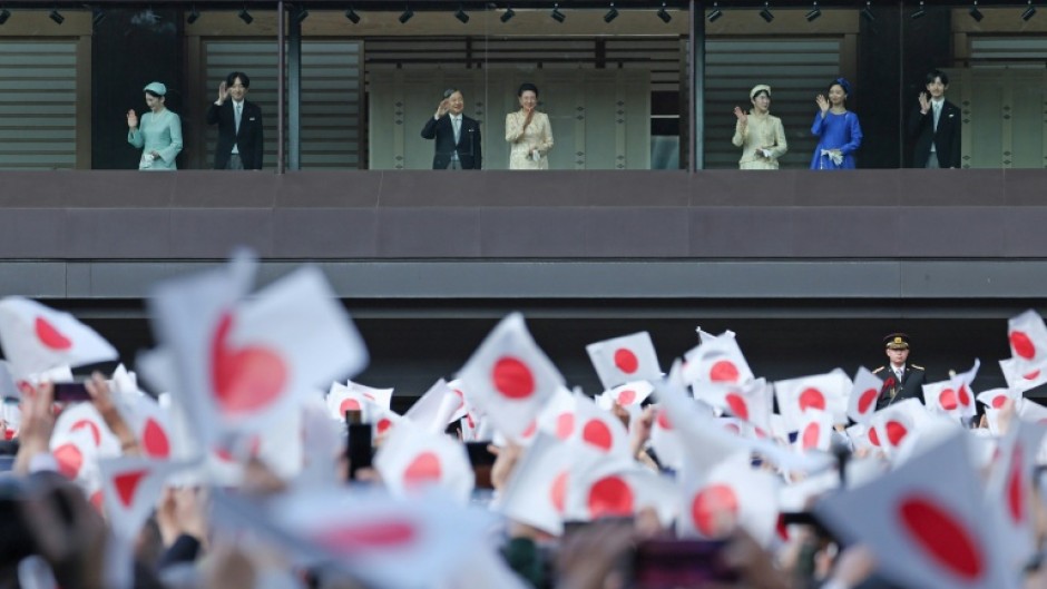Japan's Emperor Naruhito (centre L), Empress Masako (centre R), and other members of the Imperial Family wave to well-wishers during a public audience celebrating the Emperor's 66th birthday, at the Imperial Palace in Tokyo