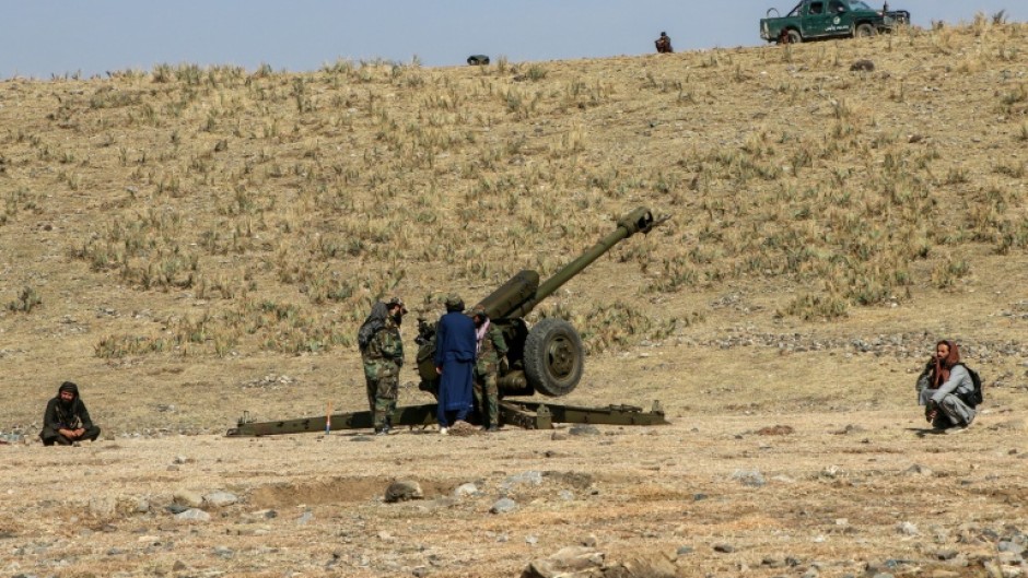 Afghan security personnel stand next to an artillery gun near the border with Pakistan, whose defence minister said both countries were at 'open war'