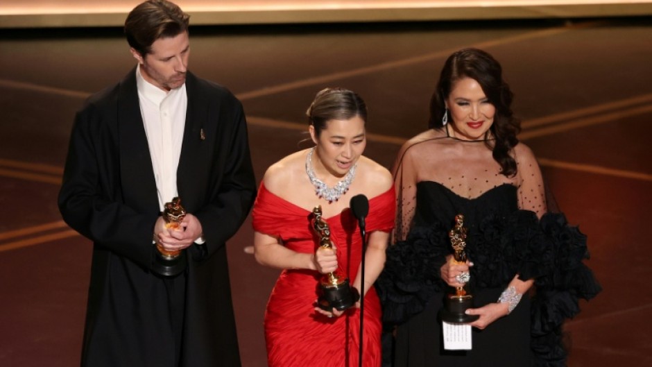 Co-director Chris Appelhans co-director Maggie Kang and producer Michelle Wong accept the Oscar for best animated feature for 'KPop Demon Hunters'