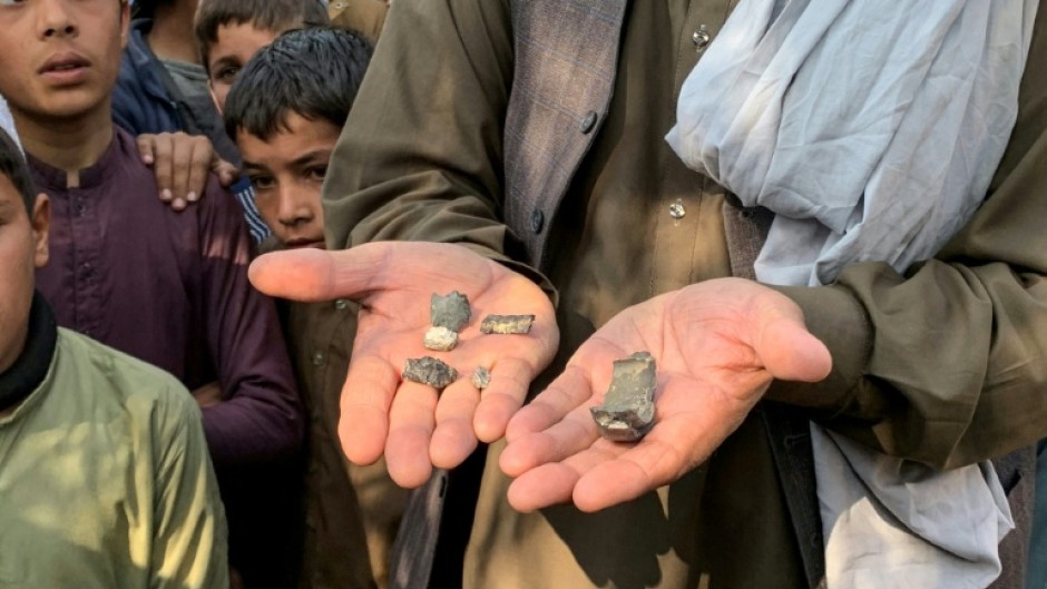 An Afghan man shows mortar shell remains in the Ghani Khel district of Nangarhar province on March 1, 2026 amid ongoing cross-border fighting between Afghanistan and Pakistan.