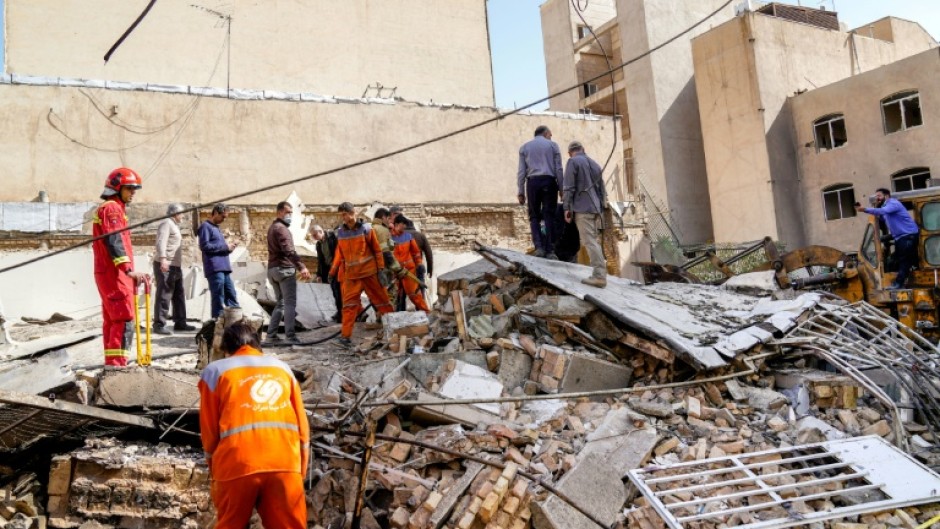 In this picture obtained from Iran's ISNA news agency, rescuers search through the rubble of a collapsed building at the site of a strike in Tehran