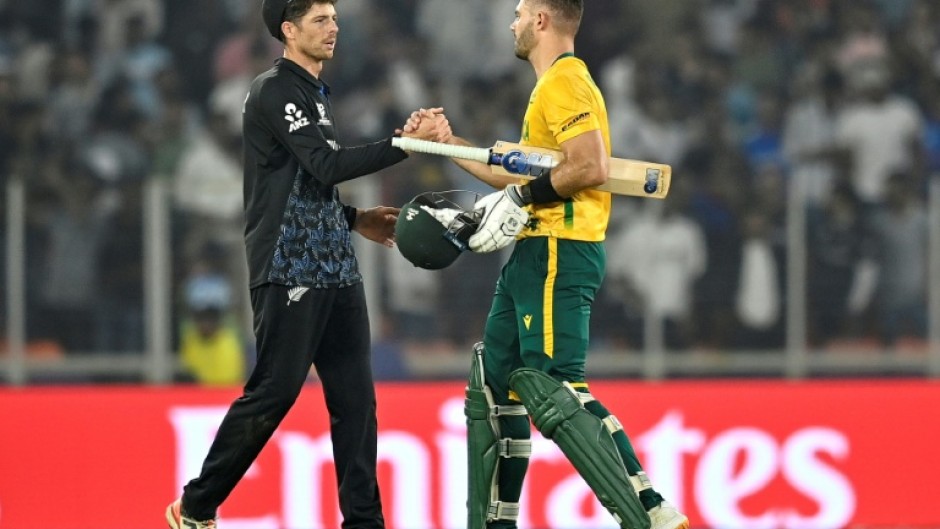 Aiden Markram (right) is congratulated by New Zealand counterpart Mitchell Santner after South Africa won their group phase clash in Ahmedabad on February 15