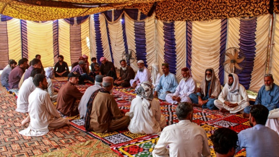 Mourners gather to offer condolences after the death of Pakistani national Muzaffar Ali, who was killed in Dubai amid the ongoing Middle East war, after his funeral in Jamshoro, in Sindh province