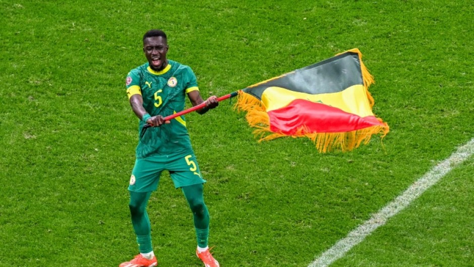 Idrissa Gueye waves the Senegal flag after his side beat Morocco on the field in the in the Africa Cup of Nations final in January