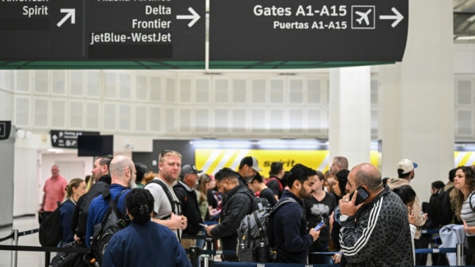 Travelers wait in line at a TSA security checkpoint at George Bush Intercontinental Airport in Houston, Texas on March 20, 2026