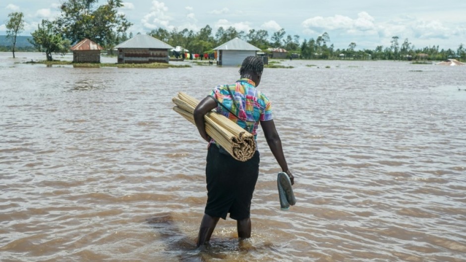 A woman in Kenya's Nyakach region wades through flooding triggered by torrential rain
