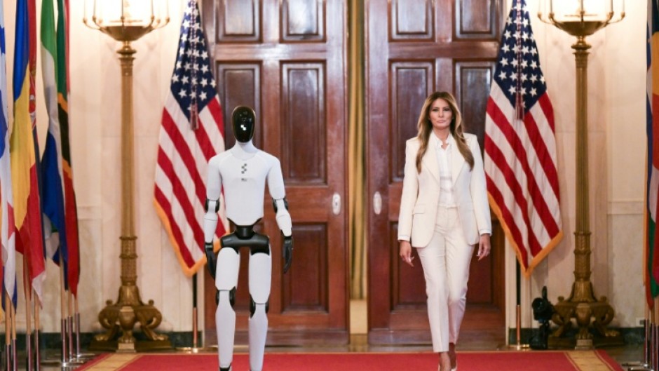 US First Lady Melania Trump walks with a humanoid robot as she arrives for the Fostering the Future Together Global Coalition Summit in the White House