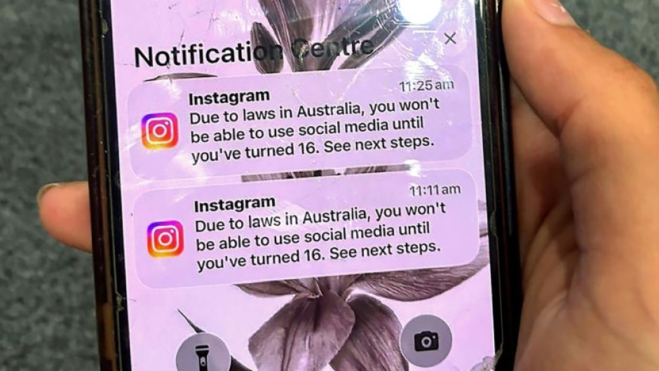 A teenager holds a phone displaying a message from social media platform Instagram after the account was locked for age verification in Australia