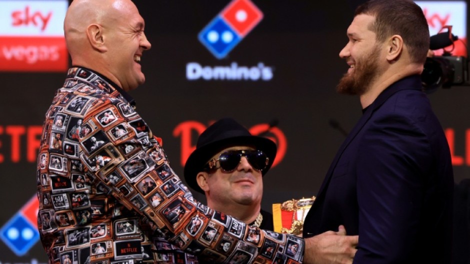 Britain's two-time former world heavyweight champion Tyson Fury (L) faces off with Russia's Arslanbek Makhmudov during a press conference ahead of their bout in London