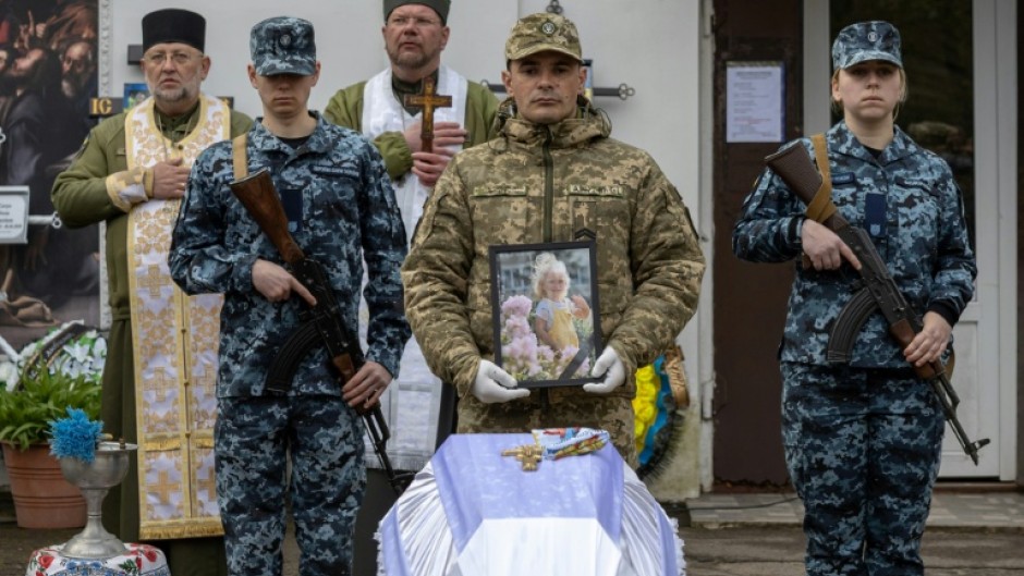 Ukraine soldiers at the funeral of a child killed in a Russian drone attack on a multi-storey residential building in Odesa