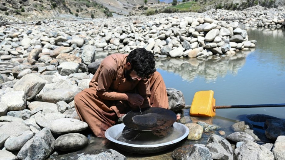 An Afghan man scours for gold using the traditional gold-panning technique allowed by authorities