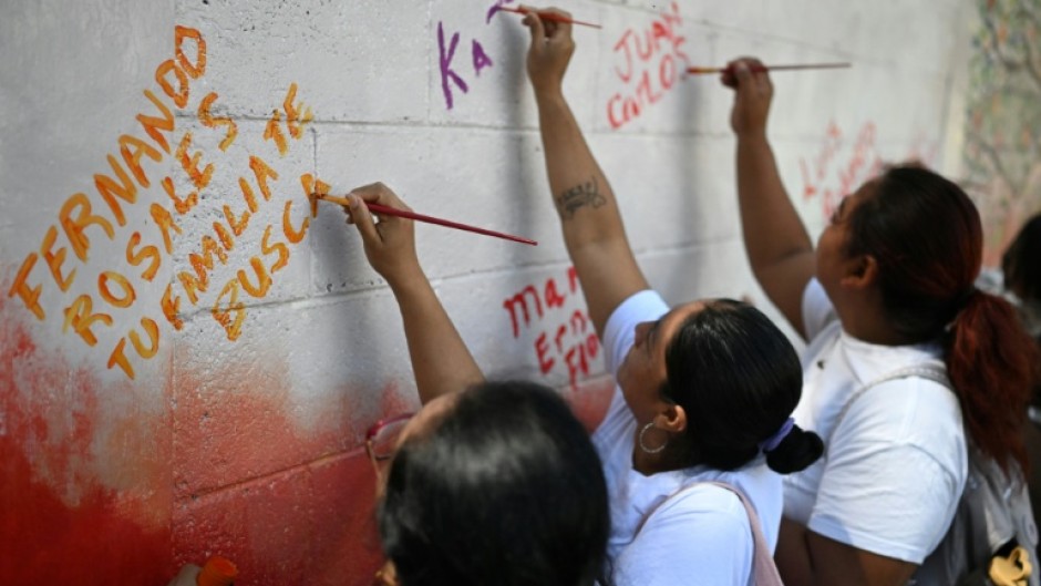 Esmeralda Rosales writes a message addressed to her missing brother, Fernando Rosales, during the inauguration of a mural in tribute to disappeared people, at the University of El Salvador, in San Salvador, on March 19, 2026