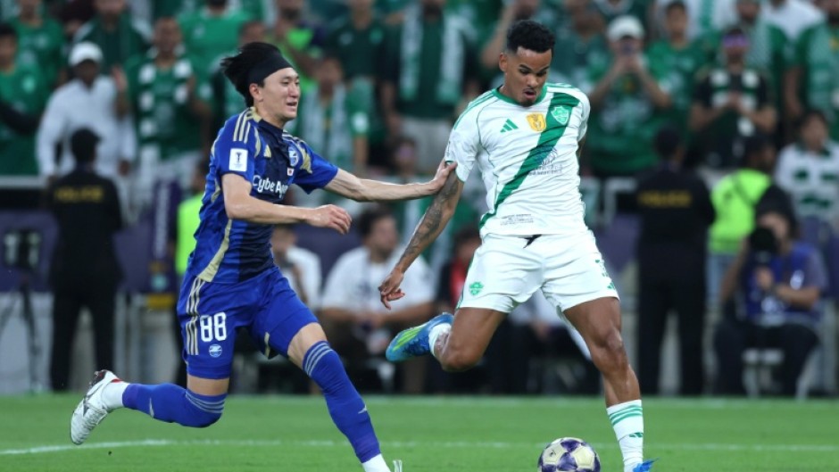 FC Machida Zelvia's Japanese defender Hotaka Nakamura (L) fights for the ball with Al Ahli's Brazilian forward Galeno