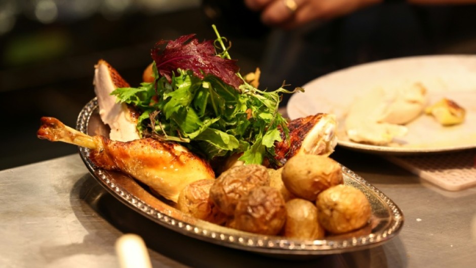 A cook prepares a rotisserie chicken with potatoes during dinner in the French restaurant Gigi’s in the Brooklyn borough of New York City on April 26, 2026