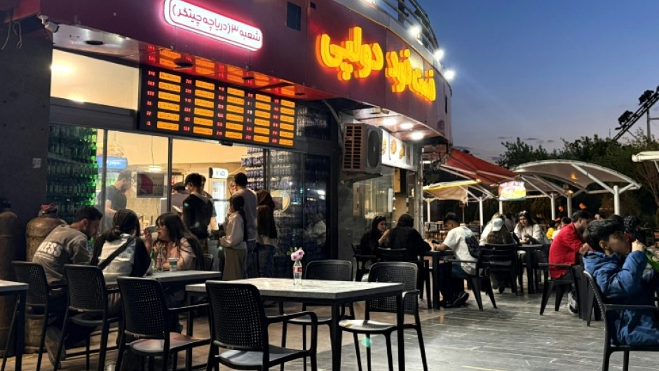 Iranians gather at an eatery in northwestern Tehran. Despite an outward appearance of normality, many are under severe financial strain