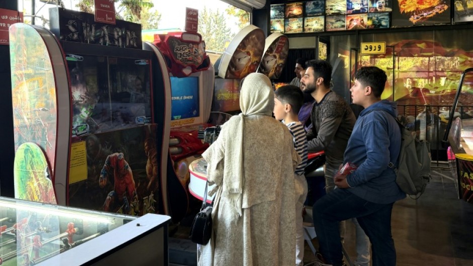 Iranians play games at an arcade in the capital. While some are trying to return to normal life under the ceasefire, others can't afford leisure activities