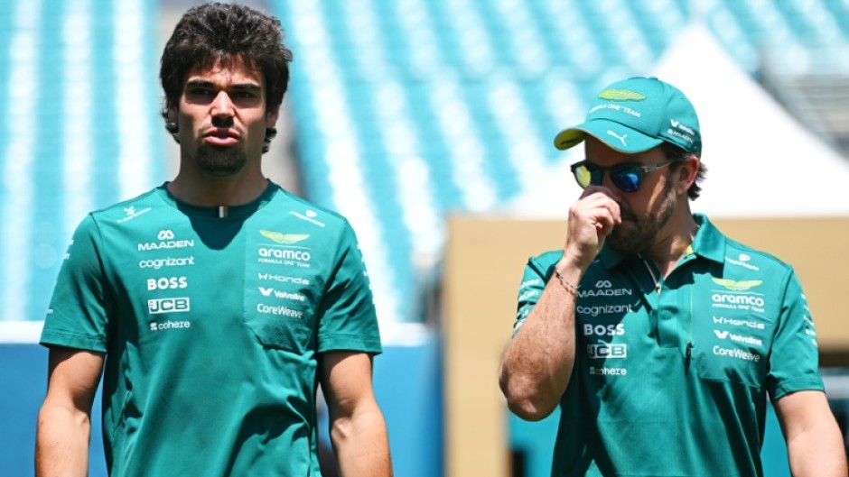 Good vibrations: Aston Martin drivers Lance Stroll and Fernando Alonso walk in the paddock before the Miami Grand Prix