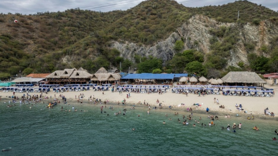 Aerial view of Playa Blanca beach in the Colombian region of Santa Marta, where mountains sweep down through jungle to the Caribbean