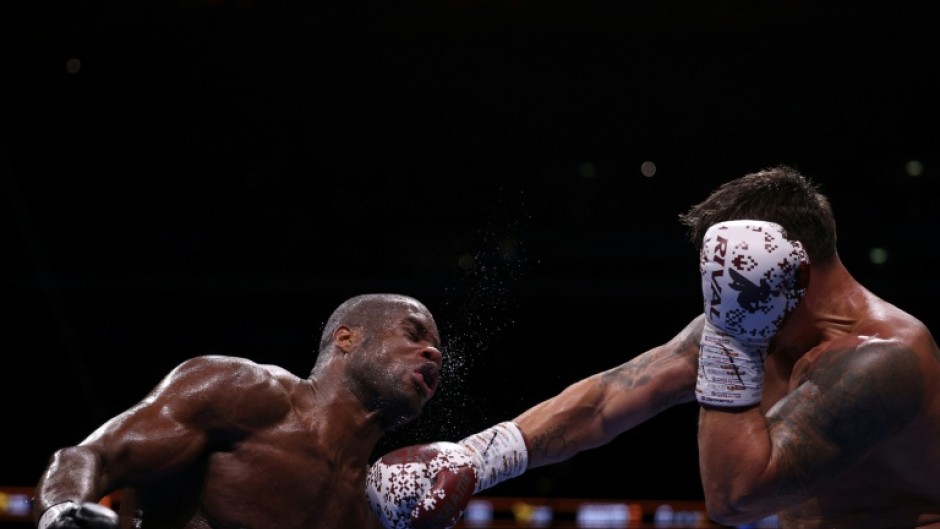 Daniel Dubois (L) takes a punch from champion Oleksandr Usyk during an undisputed world heavyweight title bout at London's Wembley Stadium in July last year