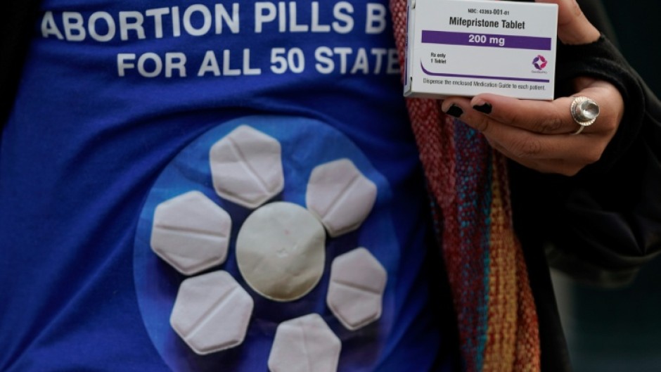 An abortion rights activist holds a box of mifepristone during a rally in front of the US Supreme Court on March 26, 2024, in Washington, DC