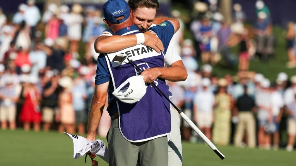 Norway's Kristoffer Reitan, back, hugs his caddie on the 18th green after winning his first US PGA Tour title at the Truist Championship at Quail Hollow