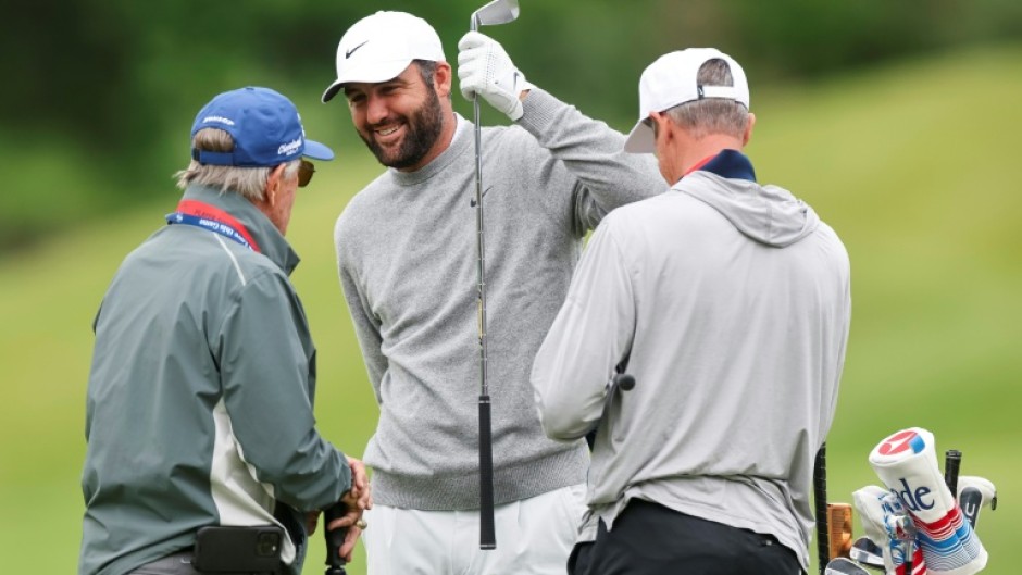 Top-ranked defending champion Scottie Scheffler, center, talks with caddie Ted Scott, right, and swing coach Randy Smith during a practice round at Aronimink ahead of the 108th PGA Championship